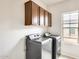 Laundry room featuring a window, washer, dryer, and overhead cabinets for storage at 9435 S 33Rd Dr, Laveen, AZ 85339
