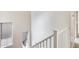 View of the stairwell with a white railing and gray carpet on the stairs and natural light coming from the windows at 9435 S 33Rd Dr, Laveen, AZ 85339