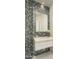 Stylish powder room with unique blue and gray tile accent wall, modern vanity, and decorative lighting at 9726 E Hidden Green Dr, Scottsdale, AZ 85262