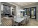 Bright dining room with a large table, modern chandelier, and sliding glass doors to the backyard patio at 9726 E Hidden Green Dr, Scottsdale, AZ 85262