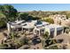 Stunning home exterior with desert landscaping, a circular driveway, and mountain views in the background at 9726 E Hidden Green Dr, Scottsdale, AZ 85262