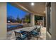 Covered patio with stone tile, dining table, and pool with view of Arizona desert landscape and saguaro cactus at 9726 E Hidden Green Dr, Scottsdale, AZ 85262