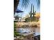 Poolside view with Troon North hat, golf ball, martini, and saguaro cactus at resort-style luxury home at 9726 E Hidden Green Dr, Scottsdale, AZ 85262