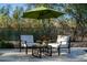 Poolside lounge area with comfortable chairs, shade umbrella, refreshments, and view of lush landscaping at 9726 E Hidden Green Dr, Scottsdale, AZ 85262