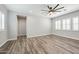 Spacious bedroom with wood-look floors, a ceiling fan, and bright, shuttered windows at 9903 E Rotation Dr, Mesa, AZ 85212