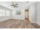 Bedroom offering wood-look floors, ceiling fan, tv, and shuttered windows at 9903 E Rotation Dr, Mesa, AZ 85212