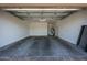 Spacious, empty two car garage with concrete floor and neutral colored walls at 9903 E Rotation Dr, Mesa, AZ 85212