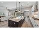 Open-concept kitchen with granite island, stainless appliances, pendant lights, and backyard views at 9903 E Rotation Dr, Mesa, AZ 85212