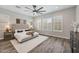 Bright main bedroom featuring wood floors, a ceiling fan, and large windows with plantation shutters at 9903 E Rotation Dr, Mesa, AZ 85212