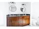 Bright bathroom features a double sink vanity, granite countertop, and round mirrors at 3907 E Marilyn Rd, Phoenix, AZ 85032