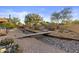 Expansive backyard with desert landscaping, rock features, bridge, cacti, hammock, and dining area at 8625 E Camino Vivaz --, Scottsdale, AZ 85255