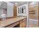Bathroom featuring vanity with granite counters, wood cabinets, and a large mirror at 8625 E Camino Vivaz --, Scottsdale, AZ 85255