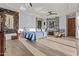 Bright main bedroom boasts unique artwork, a comfortable king bed, and hardwood floors, creating a cozy atmosphere at 8625 E Camino Vivaz --, Scottsdale, AZ 85255