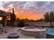 Backyard pool and spa with desert landscaping set against a vibrant sunset sky at 8625 E Camino Vivaz --, Scottsdale, AZ 85255