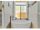 Bright bathroom featuring a soaking tub under a window overlooking the exterior at 8625 E Camino Vivaz --, Scottsdale, AZ 85255
