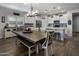 Open-concept kitchen and dining area featuring white cabinets, stainless appliances, island seating, and wood-look floors at 11148 E Tumbleweed Ave, Mesa, AZ 85212