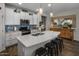 Spacious kitchen with white cabinetry, island seating, stainless steel appliances, and decorative backsplash at 11148 E Tumbleweed Ave, Mesa, AZ 85212