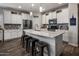 Modern kitchen boasts white cabinets, stainless steel appliances, and a large quartz island with seating at 11148 E Tumbleweed Ave, Mesa, AZ 85212