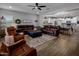 Inviting living room featuring wood-look tile flooring, leather furniture, and a seamless flow into the kitchen area at 11148 E Tumbleweed Ave, Mesa, AZ 85212