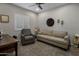 Comfortable office space featuring a sofa, recliner, desk, and shuttered windows providing a functional work environment at 11148 E Tumbleweed Ave, Mesa, AZ 85212