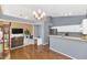 Open floor plan includes kitchen with island, dining area with chandelier and wood floors at 1313 W Glenmere Dr, Chandler, AZ 85224