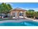 Relaxing backyard featuring a pool and a covered outdoor sitting area with a fireplace at 1313 W Glenmere Dr, Chandler, AZ 85224