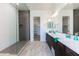 Bright bathroom featuring double sinks, a walk-in shower, and convenient access to the walk-in closet at 14429 N 75Th Dr, Peoria, AZ 85381