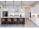 Modern kitchen with white cabinets, stainless steel appliances, large island and stylish pendant lighting at 14429 N 75Th Dr, Peoria, AZ 85381