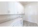 Practical laundry room with white cabinetry, plenty of counter space, and space for washer and dryer at 14429 N 75Th Dr, Peoria, AZ 85381