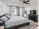Bright bedroom featuring a ceiling fan, large dresser, area rug and ample natural light at 1550 N Stapley Dr # 21, Mesa, AZ 85203