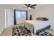 Well-lit bedroom featuring a surfboard, a modern ceiling fan, and a stylish geometric-patterned rug at 1550 N Stapley Dr # 21, Mesa, AZ 85203