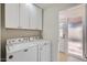 Laundry room featuring a Maytag washer and dryer, white cabinets, and a textured glass exterior door at 1550 N Stapley Dr # 21, Mesa, AZ 85203