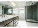 Modern bathroom with a large mirror, dual sink vanity, and glass-enclosed shower with dark tiling at 1565 E Tiffany Way, Gilbert, AZ 85298