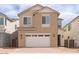 Two-story home featuring a two-car garage, tan stucco, and manicured landscaping at 1565 E Tiffany Way, Gilbert, AZ 85298