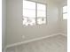 Bedroom with a large window offering neighborhood views, neutral carpet, and light-colored walls at 1571 E Tiffany Way, Gilbert, AZ 85298
