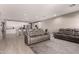 Open-concept living room with gray sofas and flows into the kitchen with white cabinets at 1644 E Joelle Dr, Casa Grande, AZ 85122
