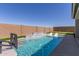 Backyard with a stunning pool, built-in lounge chairs, a basketball hoop, and a putting green, great for fun and relaxation at 1644 E Joelle Dr, Casa Grande, AZ 85122