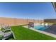Lush backyard with a refreshing pool, a fun basketball hoop, and artificial turf for easy maintenance and recreational activities at 1644 E Joelle Dr, Casa Grande, AZ 85122