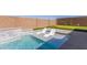 Inviting pool featuring a tanning ledge and two modern white lounge chairs and a putting green in a well manicured backyard at 1644 E Joelle Dr, Casa Grande, AZ 85122