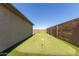 Wide view of putting green with multiple holes in a well-maintained backyard, enclosed by a tall block fence for privacy at 1644 E Joelle Dr, Casa Grande, AZ 85122