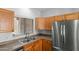 Functional kitchen area featuring stainless steel appliances, wood cabinetry, and a double-basin sink at 1650 S Crismon Rd # 6, Mesa, AZ 85209
