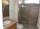 Bathroom featuring a tiled glass shower, and a wood cabinet sink at 18001 N Timber Ridge Dr, Surprise, AZ 85374