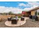 Inviting backyard with a fire pit, covered patio, desert landscaping, and a cozy outdoor seating area at 18368 W Long Lake Rd, Goodyear, AZ 85338