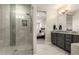 Bathroom featuring a glass enclosed shower, double sink vanity and tiled floor at 18368 W Long Lake Rd, Goodyear, AZ 85338