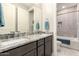 Bathroom boasts a granite countertop with dual sinks and a tiled shower over the tub at 18368 W Long Lake Rd, Goodyear, AZ 85338
