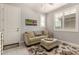 Light-filled living area featuring a comfortable sofa, ottoman and stylish window shutters at 18368 W Long Lake Rd, Goodyear, AZ 85338