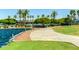 Walkway to the community pool featuring landscaped grounds, lake views, and palm trees at 18368 W Long Lake Rd, Goodyear, AZ 85338