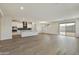 Spacious open-concept kitchen with white cabinets, a dark backsplash and an island with bar seating at 19039 W Rose Ln, Waddell, AZ 85355