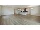 Open-concept kitchen with white cabinets and dark backsplash overlooking the living and dining areas at 19039 W Rose Ln, Waddell, AZ 85355
