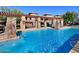 A large community pool with a stone waterfall feature, pergola, and lounge areas for relaxing at 20100 N 78Th Pl # 2203, Scottsdale, AZ 85255